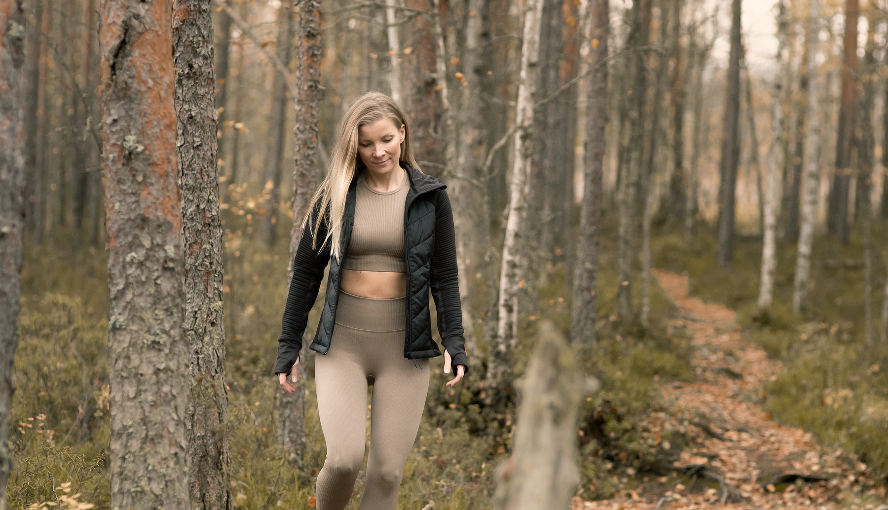 Nainen kävelee syksyisessä metsässä